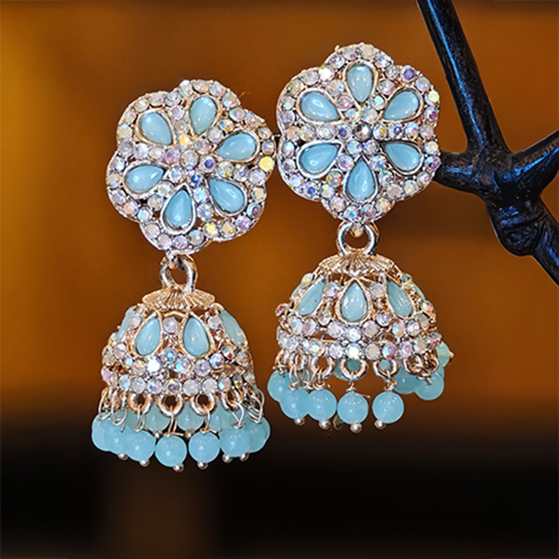 Pair of turquoise gemstone earrings with gold accents on a dark background